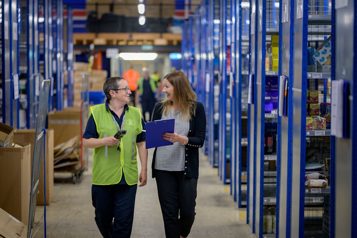 Stock controllers auditing inventory in a warehouse aisle