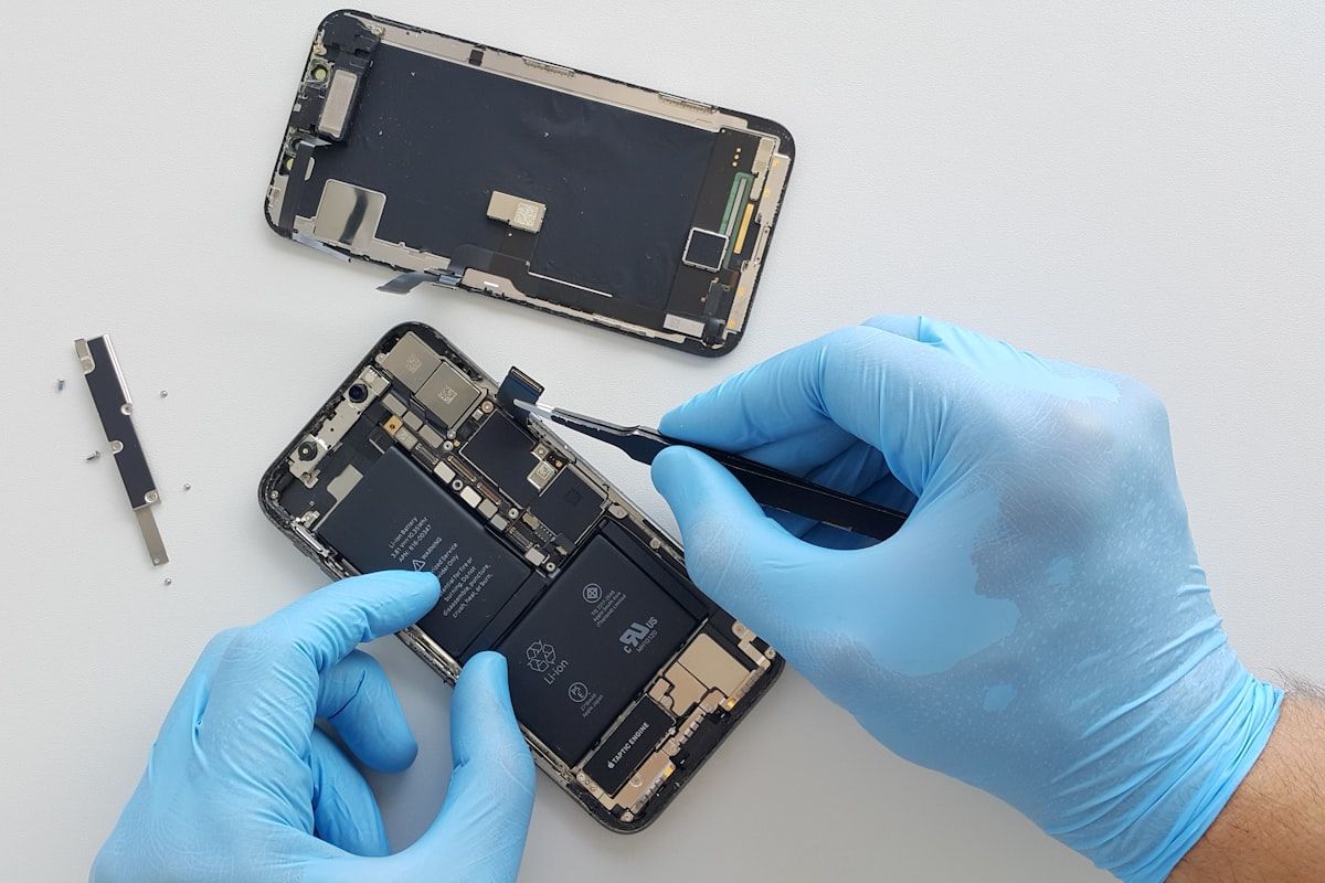 Technician replacing a mobile phone screen assembly