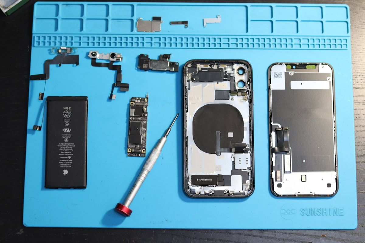 Disassembled smartphone components laid out on a work mat